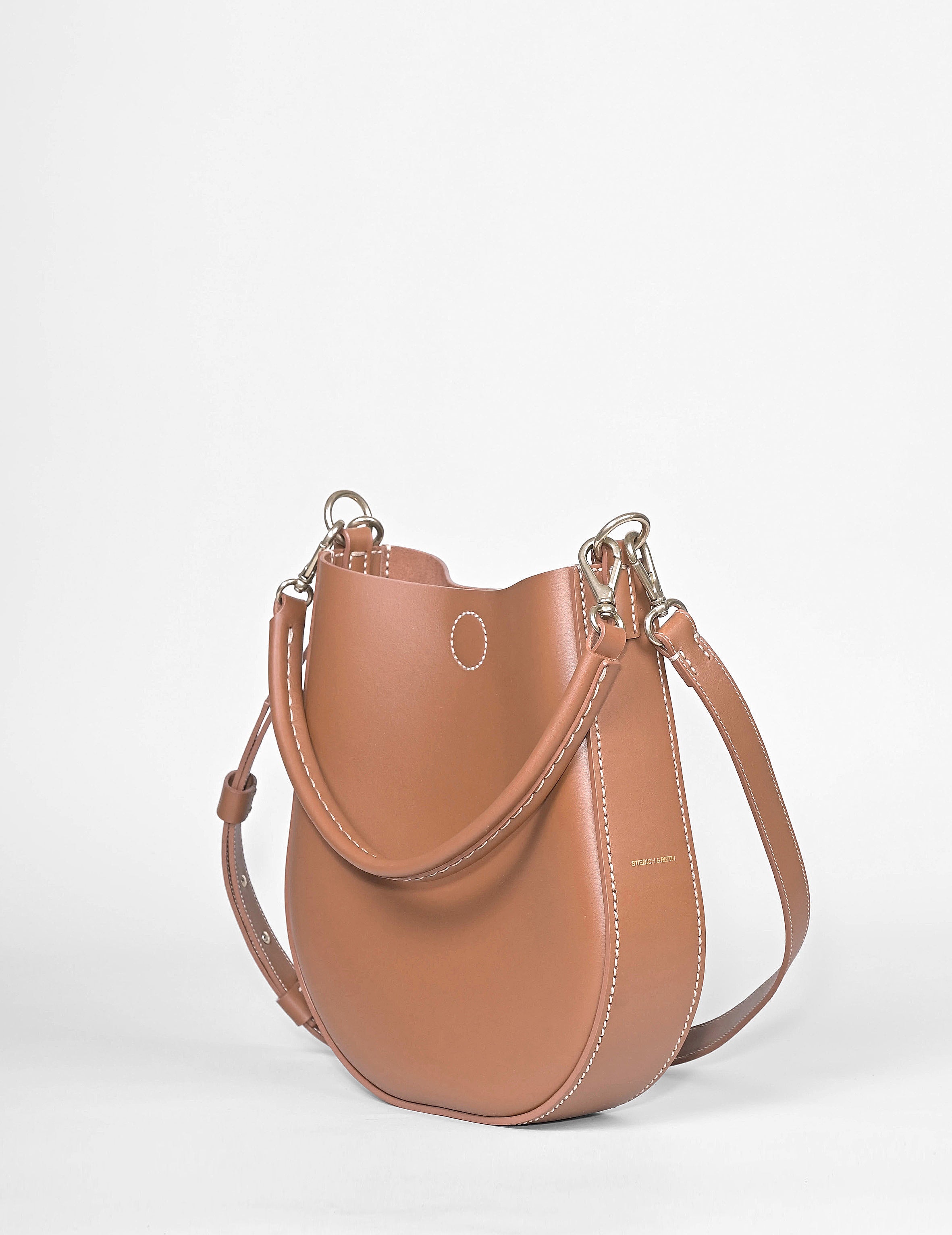 LOOP Schultertasche aus braunem Rindsleder mit Kurzhenkel und verstellbarem Schulterriemen mit Karabinern, Seitenansicht